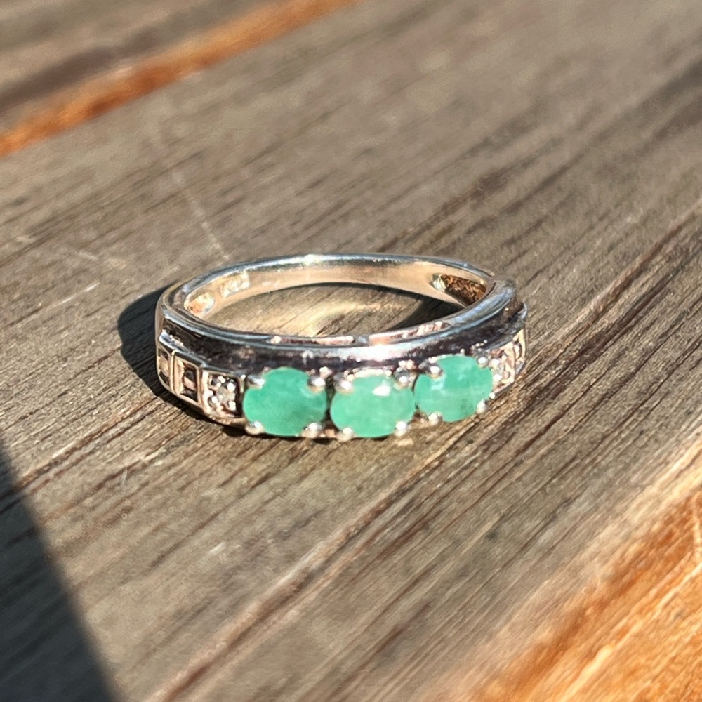 Elegant 925 silver ring with green gemstones and clear stones.